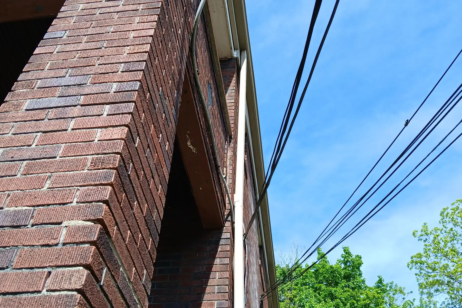 The corner of a brick building running up against open sky