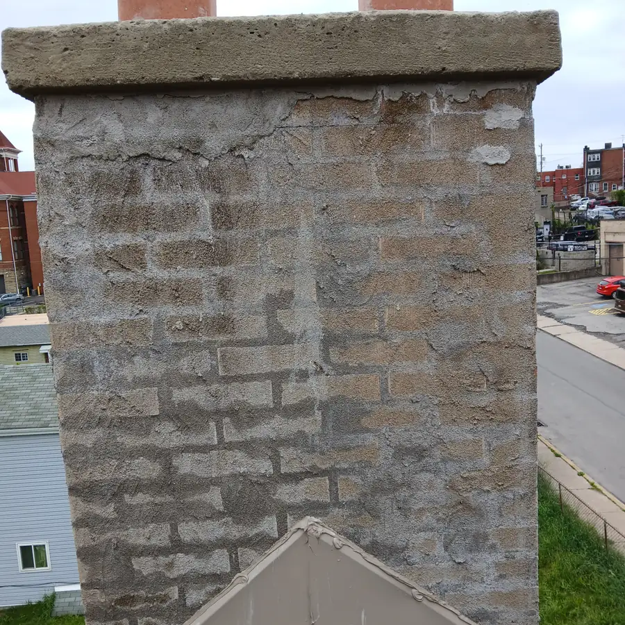 After: the same chimney parged over with a new poured crown on top