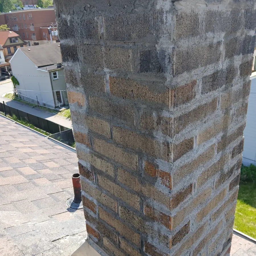 Before: the bare brick chimney stack with no crown on top