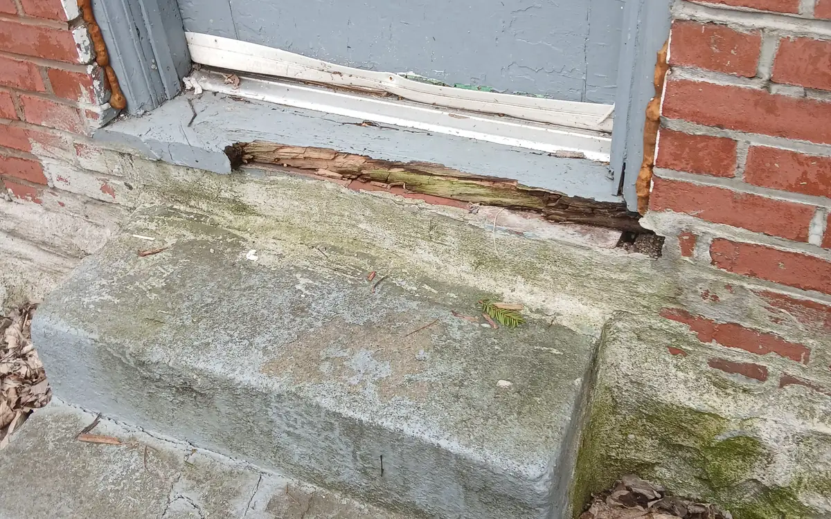 A doorway threshold where the stone and brickwork below the frame has broken down